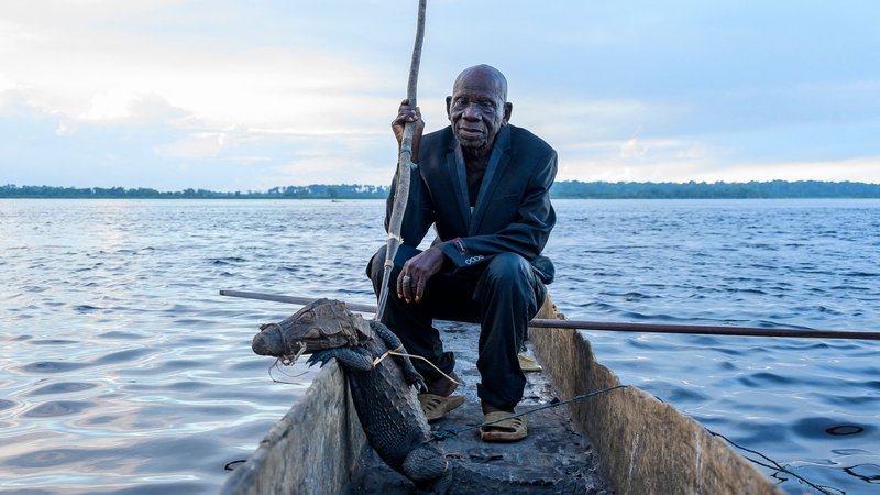 Fotografija: 91 letni legendarni lovec Papa Baron Missiki, pozira s krokodilom in kopjem na pirogi na reki Kongo. Papa Baron Missiki je lovil krokodile, bivole, antilope, slone in hrošče. Zdaj je upokojen, vendar njegov sin, ki se prav tako imenuje Missiki, sledi njegovim stopinjam. Papa se spominja časov med leti 1971 in 1997, ko je bil lov na krokodile zelo donosen. DR Kongo je bil v tistih časih znan kot Zair. Foto: Arsene Mpiana/Afp

 