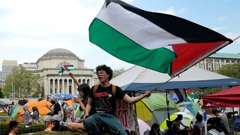 Fotografija: Študenti zasedajo propalestinski tabor »Gaza Solidarity Encampment« na zelenici Univerze Columbia v New Yorku. Na Univerzi Columbia, ki je epicenter vala propalestinskih protestov po ameriških kampusih, so se včeraj povečale napetosti, saj so oblasti napovedale prekinitev pogovorov s študenti in pozvale k odstranitvi njihovega tabora z območja univerze. Foto: Timothy A. Clary/Afp