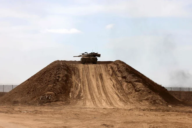 Izraelski tank na peščeni gori v Gazi. FOTO: Menahem Kahan/AFP