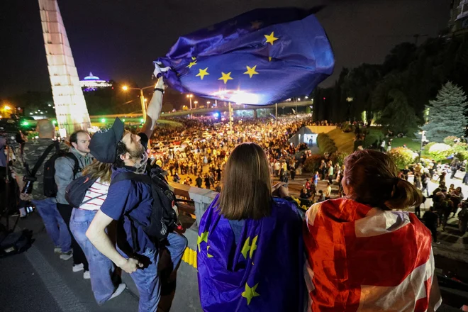 Protestniki, opremljeni z zastavami Evropske unije, med četrtkovim shodom proti spornemu zakonu o preglednosti vplivov iz tujine. FOTO: Irakli Gedenidze/Reuters
