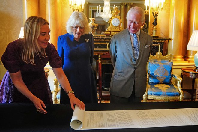 V Buckinghamski palači sta s soprogo v minulih dneh sprejela ilustrirani zapis kronanja Karla III. na kar 21-metrskem zvitku, ki ga je ustvarila kaligrafka Stephanie von Werthern-Gill. To je uradni državni zapis o monarhovem kronanju. FOTO: Victoria Jones/AFP