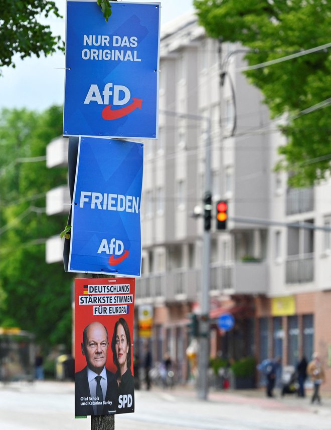 Plakati strank SPD in AfD na drevesu na dan protesta za demokracijo in proti nasilju. FOTO: Matthias Rietschel/Reuters