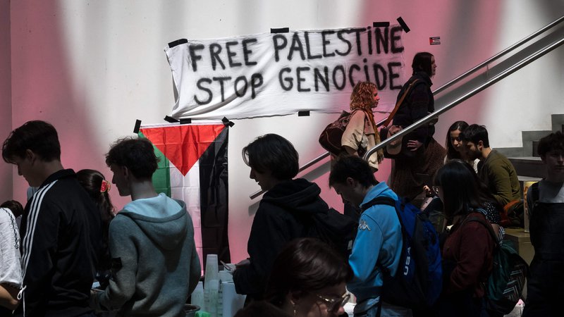 Fotografija: Transparent v dvorani Univerze v Ženevi (UNIGE), ki so jo zasedli propalestinski študentski protestniki in aktivisti. FOTO: Fabrice Coffrini/AFP