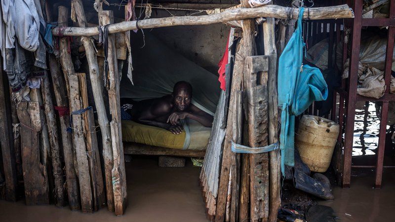 Fotografija: Moški ocenjuje višino vode iz svoje postelje na poplavljenem območju v Garissi. Kenija se spopada z eno najhujših poplav v novejši zgodovini, ki je zadnja v vrsti vremenskih katastrof po tednih ekstremnih padavin, ki jih znanstveniki povezujejo s spreminjajočim se podnebjem. Vsaj 257 ljudi je umrlo, več kot 55.000 gospodinjstev pa je bilo razseljenih, saj so kalne vode zalile cele vasi, uničile ceste in poplavile jezove. Foto: Luis Tato/Afp