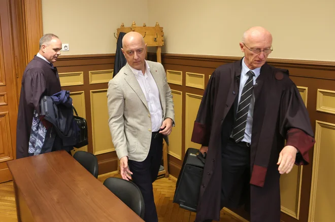 Poslovnež Mihael Strmljan v spremstvu odvetniških težkokategornikov ni želel odgovarjati na vprašanja o svojem odnosu s finančnim ministrom Klemnom Boštjančičem. FOTO: Dejan Javornik