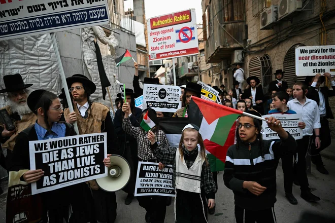 Člani protisionistične skupine hasidskih Judov Neturei Karta nosijo napise na shodu proti ustanovitvi države Izrael v jeruzalemski četrti Mea Shearim 14. maja 2024, ko država obeležuje 76. obletnico ustanovitve. Foto: Ronaldo Schemidt/Afp