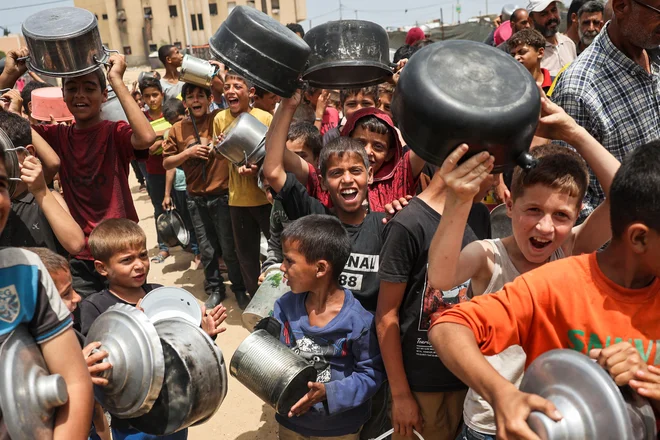 Palestinski otroci čakajo v vrsti za hrano v Rafi na jugu Gaze.. Izraelski vdor v mesto Rafa na jugu Gaze, ki se je začel ob mednarodnem ogorčenju, je poglobil že tako nevarno humanitarno krizo. Foto: Afp