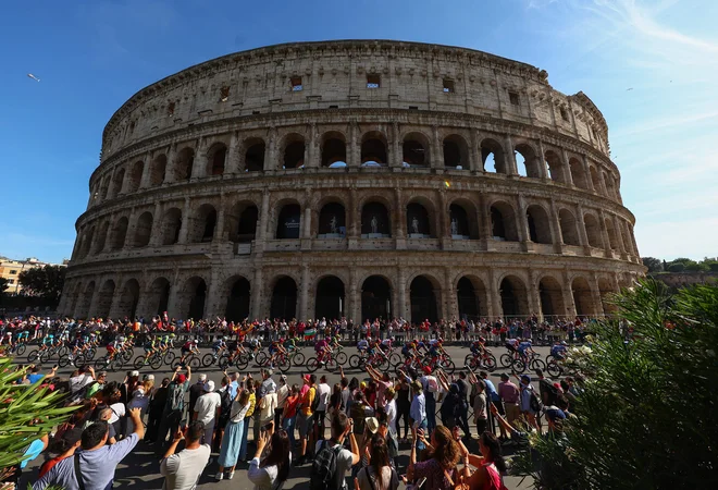 TOPSHOT - The pack of riders (peloton) cycles past the Colosseum during the 21st and last stage of the 107th Giro d'Italia cycling race, 125km from Rome to Rome on May 26, 2024. (Photo by Luca Bettini/AFP) Foto Luca Bettini Afp