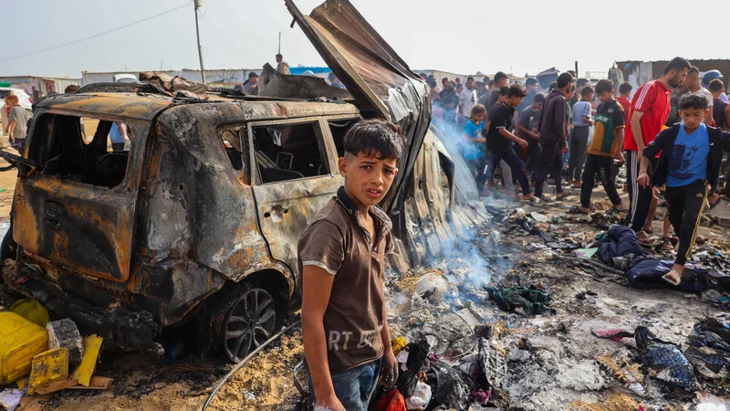 Izraelske rakete so namreč zadele veliko šotorsko naselje, ki se nahaja ob skladišču Agencije Združenih narodov za pomoč palestinskim beguncem. Foto Eyad Baba/AFP