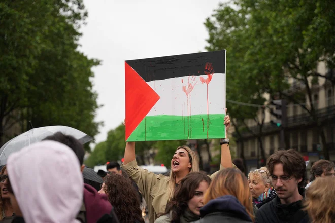 Protestnik s palestinsko zastavo v Parizu. FOTO: Zakaria Abdelkafi/AFP