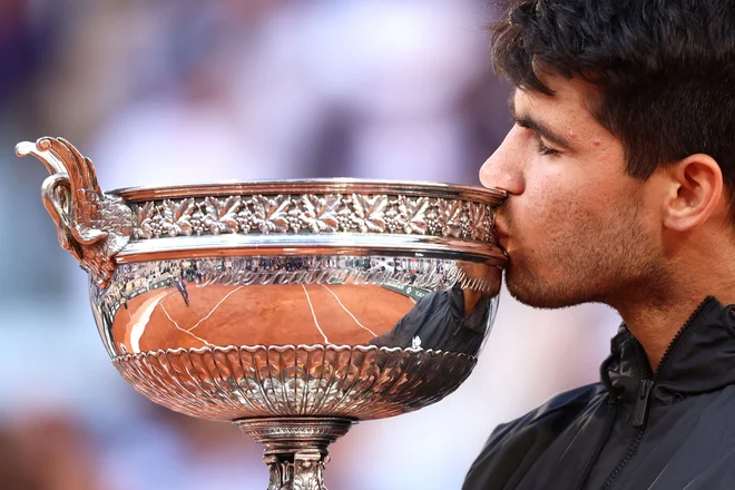 Carlos Alcaraz je takole poljubil zmagoviti pokal. FOTO: Emmanuel Dunand/AFP