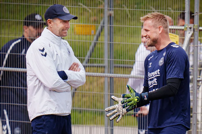 Danski selektor Kasper Hjulmand (levo) in vratar Kasper Schmeichel dobro razpoložena pričakujeta tekmo s Slovenijo. FOTO: Liselotte Sabroe/AFP