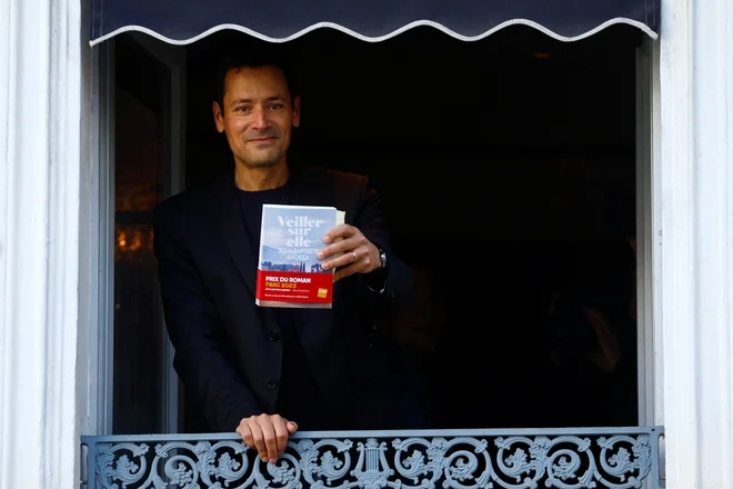 Jean-Baptiste Andrea je ob prejemu goncourta 2023 pomahal novinarjem iz prvega nadstropja restavracije Drouant. FOTO: Gonzalo Fuentes/Reuters