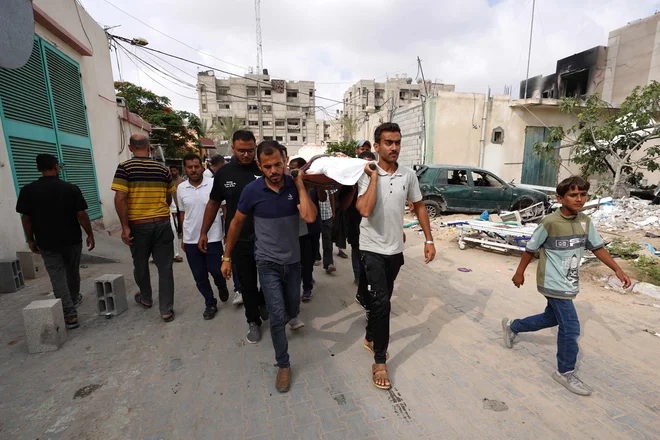 Palestinski možje nosijo žrtve streljanja na pravi pokop. FOTO: Bashar Taleb/AFP
