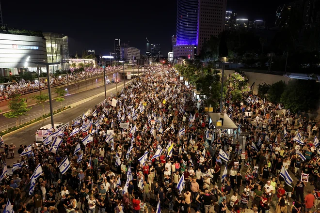 V Tel Avivu se je po navedbah organizatorjev zbralo okoli 150.000 ljudi, ki so med drugim imeli na plakatih napise »Ustavite vojno« in »Minister za zločine«. FOTO: Eloisa Lopez/Reuters