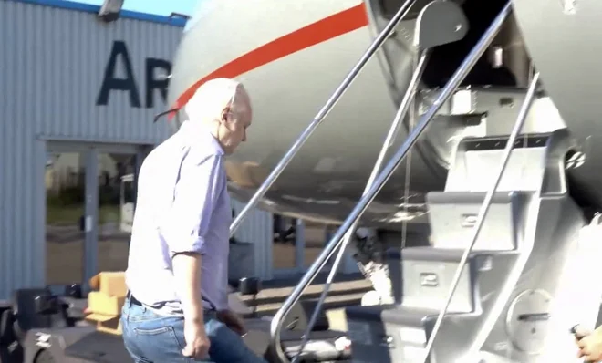 Julian Assange vstopa v letalo na londonskem letališču Stansted. FOTO: Afp