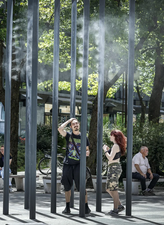 Za ohladitev v vročih poletnih dneh poskrbijo pršilniki z vodo, nameščeni na Čufarjevi ulici. FOTO: Jože Suhadolnik/Delo