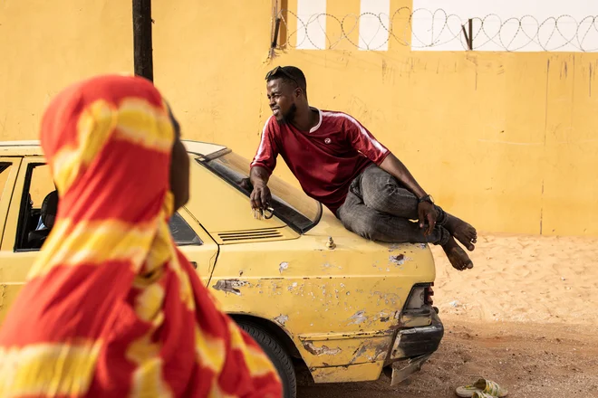Moški sedi na avtomobilu pred voliščem v Nouakchottu. Mavretanijci so šli preteklo soboto na volišča, kjer so odločali, ali bodo ponovno izvolili predsednika Mohameda Ould Cheikha El Ghazouanija na čelo obsežne puščavske države, ki velja za oporišče relativne stabilnosti v nestabilnem Sahelu. Približno 1,9 milijona registriranih volivcev bo izbiralo med sedmimi kandidati, ki se potegujejo za vodenje zahodnoafriške države, ki se je v veliki meri uprla valu džihadizma v regiji in naj bi postala proizvajalka plina. Foto: John Wessels/Afp