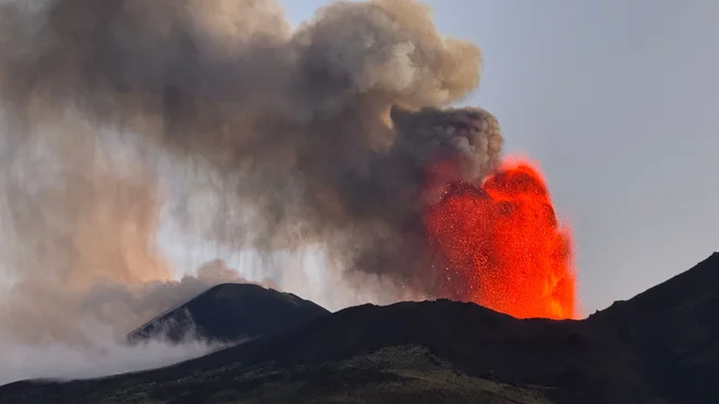 Etna, ki leži na vzhodu Sicilije, je v zadnjih mesecih večkrat izbruhnila. Za ljudi, ki živijo pod 3300 metrov visokim ognjenikom, izbruhi običajno ne predstavljajo nevarnosti. FOTO: Giuseppe Distefano/AFP