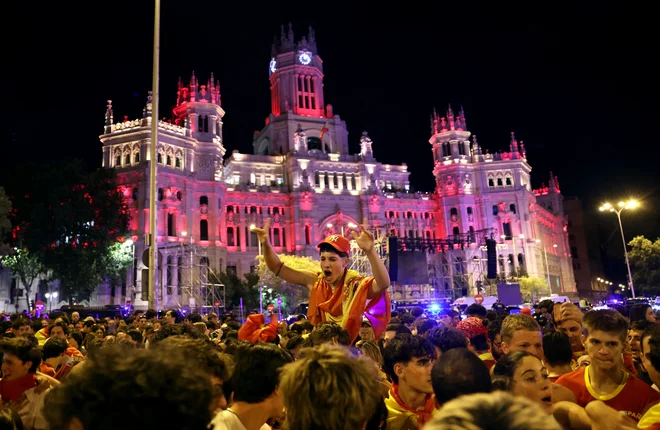 Na znamenitem madridskem trgu de Cibeles so bučno in množično pospremili veliki finale evropskega prvenstva v nogometu. FOTO: Isabel Infantes/Reuters