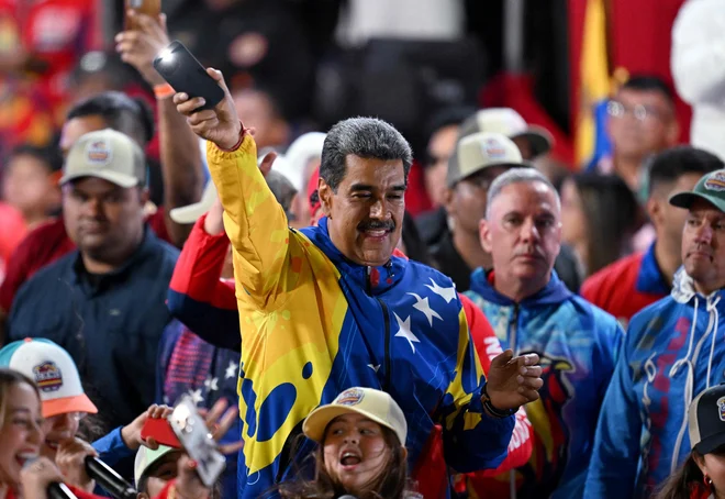 Opozicija trdi, da so se pri štetju glasov zgodile številne nepravilnosti. Maduro na fotografiji s svojimi privrženci. FOTO:  Juan Barreto/AFP