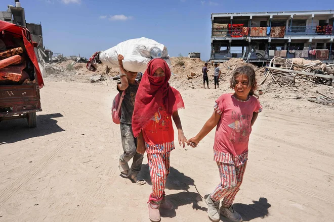 Razseljeni Palestinci se vračajo v Han Junis po poročilih, da se je izraelska vojska umaknila. FOTO: Bashar Taleb/AFP