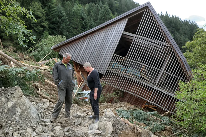 Marjeta in Dani Fale lani po ujmi ob ruševinah hleva. FOTO: Blaž Samec/Delo