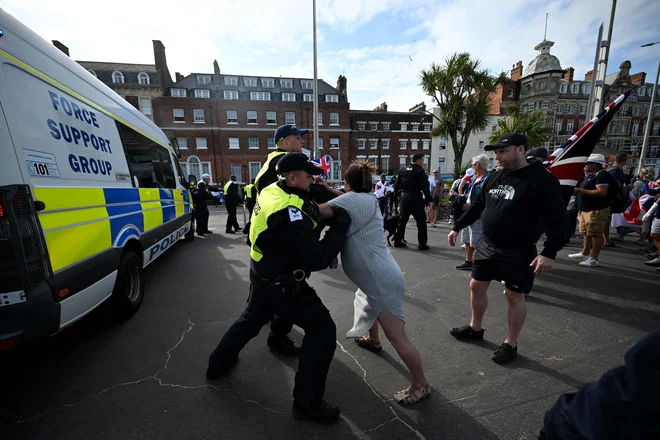 Protestnica med prerivanjem s policisti v Weymouthu na jugozahodu Anglije. FOTO: Justin Tallis/Afp