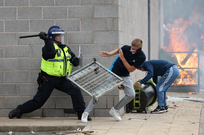 Britanski policist čaka v zasedi med protestom skrajne desnice proti priseljevanju v Rotherhamu. Foto: Hollie Adams/Reuters
