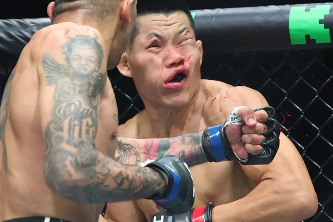 Brazilec Carlos Prates je nokavtiral Kitajca Li Jinglianga (v rdečem) v borbi velterske kategorije na turnirju Ultimate Fighting Championship (UFC) 305 v Perthu. Foto: Colin Murty/Afp