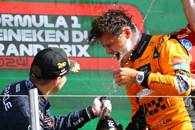 Max Verstappen (levo) je po dirki v Zandvoortu takole s penino poškropil zmagovalca Landa Norrisa. FOTO: Lisi Niesner/Reuters