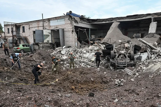 Odstranjevanje posledic ruskega raketnega napada v Krivem Rogu v osrednji Ukrajini. FOTO: Andrii Gorb/Reuters