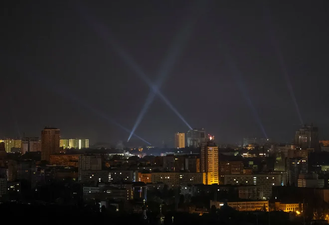 Ukrajinske sile si pri iskanju ruskih brezpilotnikov ponoči pomagajo tudi z žarometi, s katerimi osvetljujejo nebo nad Kijevom. FOTO: Gleb Garanič/Reuters