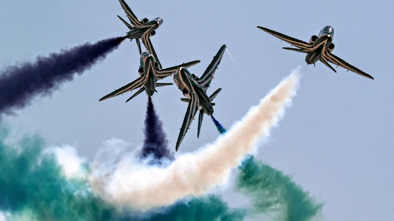 Letala BAE Hawk akrobatske skupine Saudskih sokolov spuščajo dim med izvajanjem manevrov na prvem mednarodnem letalskem salonu v Egiptu na mednarodnem letališču v Alameinu na severu Egipta. Foto: Khaled Desouki/Afp