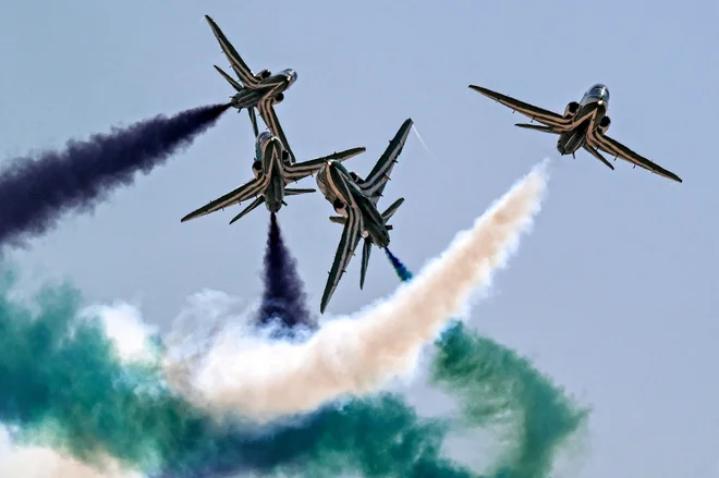 Letala BAE Hawk akrobatske skupine Saudskih sokolov spuščajo dim med izvajanjem manevrov na prvem mednarodnem letalskem salonu v Egiptu na mednarodnem letališču v Alameinu na severu Egipta. Foto: Khaled Desouki/Afp