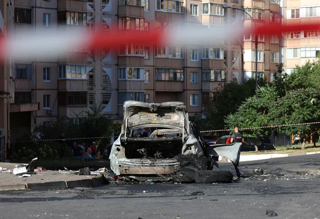 Poškodovana stavba in uničeno vozilo v Belgorodu. FOTO: Stringer Reuters
