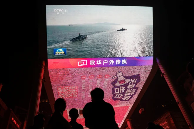 Vojaške vaje v okolici Tajvana so na Kitajskem pospremili z veliko propagandno akcijo, prebivalci Pekinga so si jih lahko ogledali celo na orjaških videozaslonih. FOTO: Tingshu Wang/Reuters