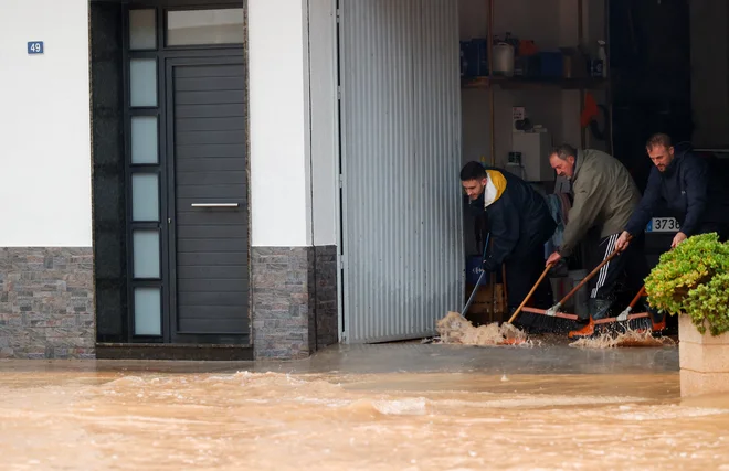 Ljudje v obupu poskušajo rešiti svoje domove. FOTO: Eva Manez/Reuters