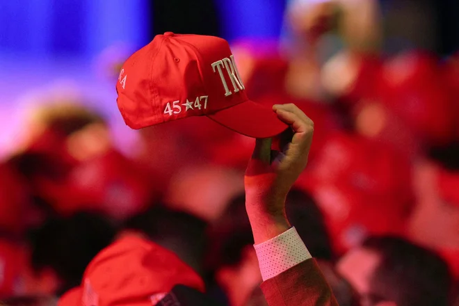 Podpornik Donalda Trumpa z rdečo kapo v rokah. FOTO: John Moore/Getty Images via AFP
