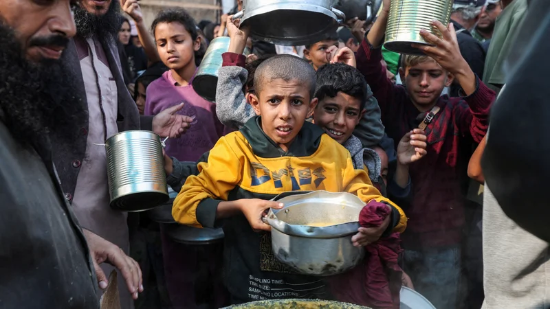 Sestradani Palestinci v vrstah čakajo na humanitarno pomoč. FOTO: Ramadan Abed/Reuters