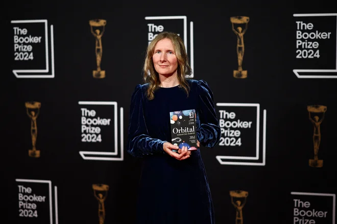 Samantha Harvey se je ob prihodu na podelitev na rdeči preprogi s takrat še ne zmagovalnim romanom nastavila fotografom. FOTO: Henry Nicholls/AFP