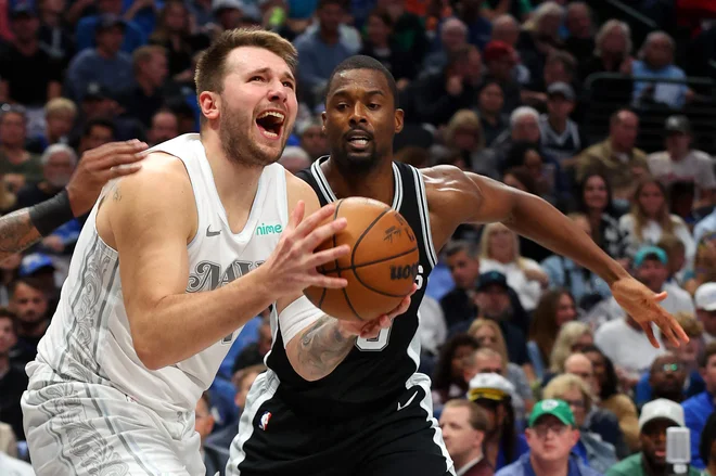 Luka Dončić je poskušal takole zadeti koš, Harrison Barnes pa ga je oviral. FOTO: Richard Rodriguez/AFP