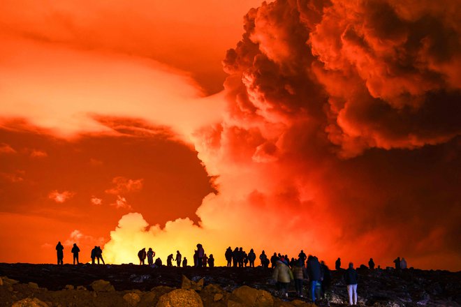 Ljudje so se marca zbrali, da bi opazovali, kako lava teče iz razpoke na polotoku Reykjanes. FOTO: Ael Kermarec/AFP