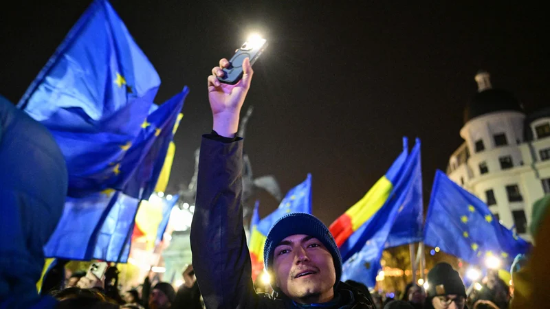 Protestniki z zastavami EU in Romunije na trgu Univerze v Bukarešti. FOTO: Daniel Mihailescu/AFP