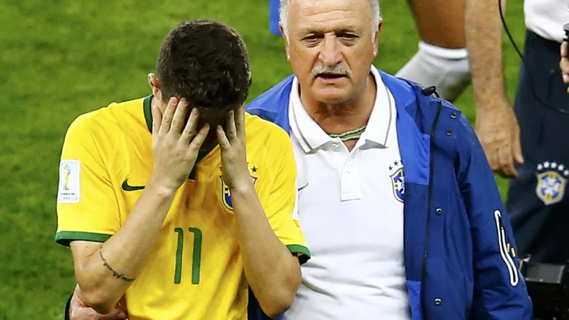 Takole je brazilski selektor Scolari tolažil Oscarja 8. julija 2014 po epski blamaži v polfinalni tekmi domačega mundiala z Nemčijo (1:7). FOTO: Leonhard Foeger/Reuters