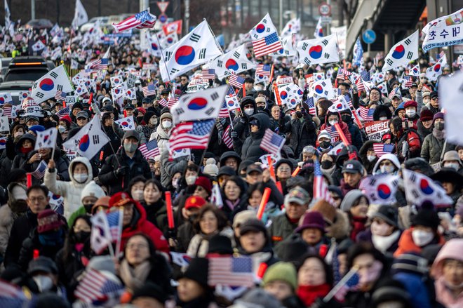 Protestniki vihtijo zastave ZDA in Južne Koreje med protestom v podporo nekdanjemu predsedniku Južne Koreje, Junu Suku Jeolu, v bližini predsedniške rezidence v Seulu. FOTO: Philip Fong/AFP