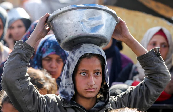 Palestinci čakajo na hrano. FOTO: Hatem Khaled/Reuters