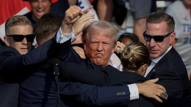 Tedaj še predsedniški kandidat Donald Trump s stisnjeno pestjo po julijskem poskusu atentata. FOTO: Brendan Mcdermid/Reuters
