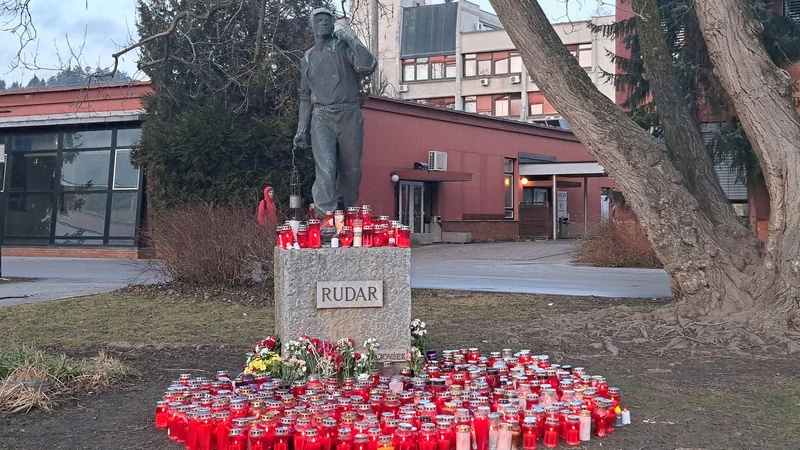 Občani so že dan po nesreči začeli k spomeniku rudarja na Titovem trgu prinašati cvetje in sveče. FOTO: Špela Kuralt/Delo