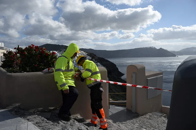 Občinski uslužbenci so z namestitvijo traku turistom prepovedali vstop v ikonično vasico Oia. FOTO: Stringer/AFP